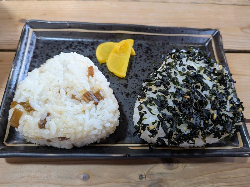 皿に並んだふきとわかめのおにぎりと、たくあん